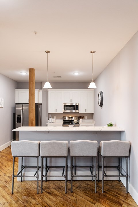 a kitchen with white cabinets and a large island with stools